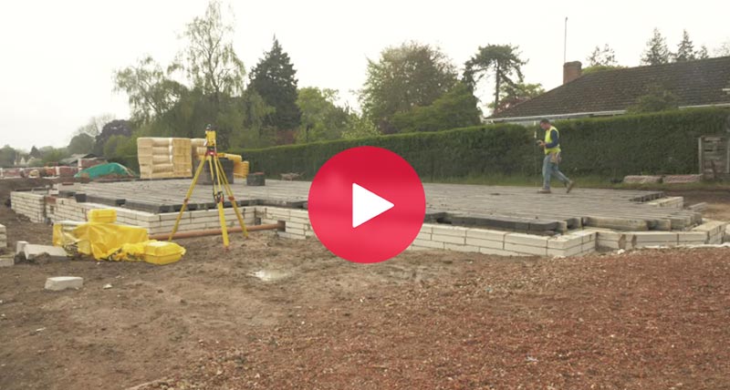 Residential building construction site with Leica iCON total station and construction worker